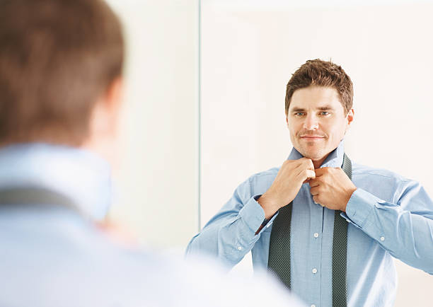 istock Businessman buttoning shirt in front of mirror 182399722