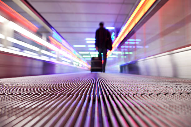 istock A silhouette of a man pulling his trolley in an escalator 182399865