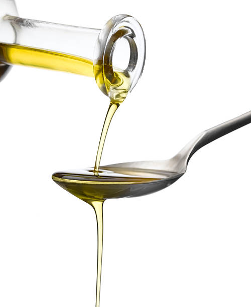istock olive oil drizzling onto spoon 182400231