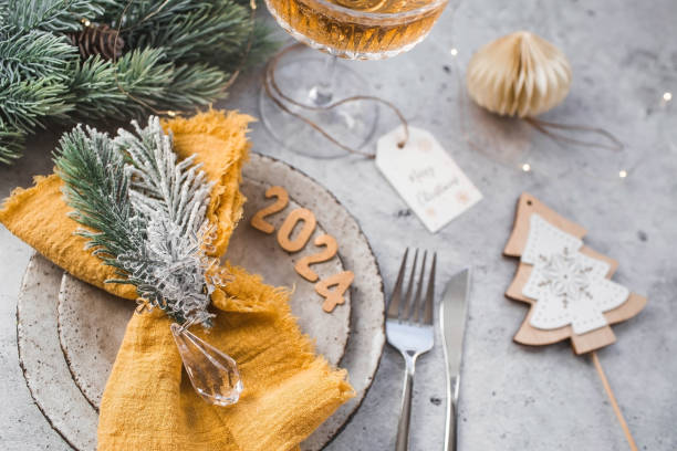 istock Table setting. Stylish plates, napkin, glass, champagne, Christmas tree branches and Christmas decorations on a gray background. The concept of merry Christmas and New Year 2024. 1824004210