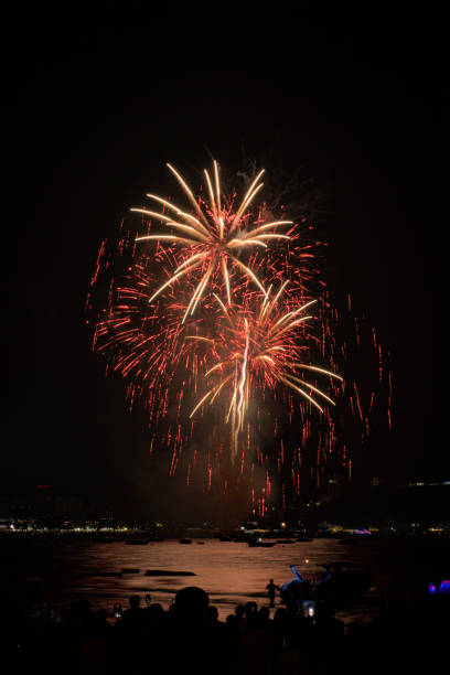 海辺の人々と街の常夜灯の背景とカラフルな花火のお祝い。 - fire firework display new year ストックフォトと画像