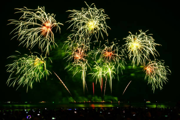 海辺の人々と街の常夜灯の背景とカラフルな花火のお祝い。 - fire firework display new year ストックフォトと画像