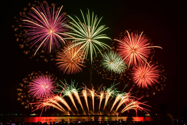istock Colorful fireworks celebration and the night sky background with crowded people on the beach. 1824007400