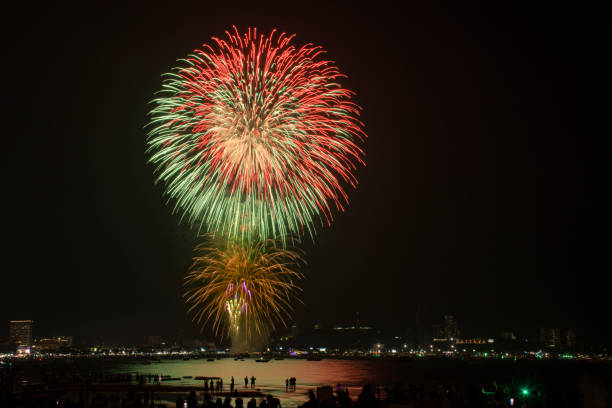 海辺の人々と街の常夜灯の背景とカラフルな花火のお祝い。 - fire firework display new year ストックフォトと画像