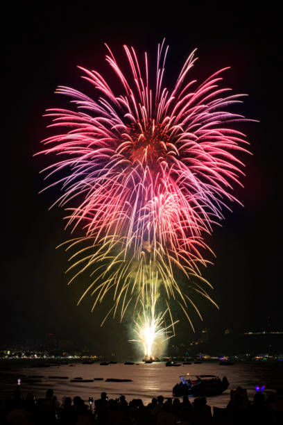 海辺の人々と街の常夜灯の背景とカラフルな花火のお祝い。 - fire firework display new year ストックフォトと画像