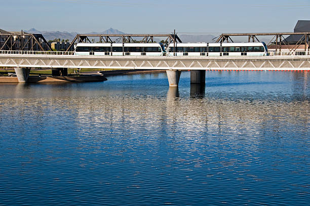 Light rail train crossing bridge over lake between Tempe and Phoenix in Arizona