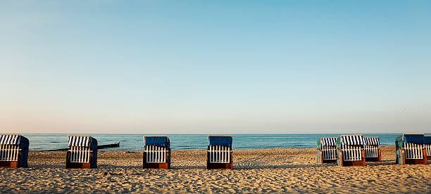 Coast of the Baltic Sea - empty beach chairs at the beach in the sunset with long shadows