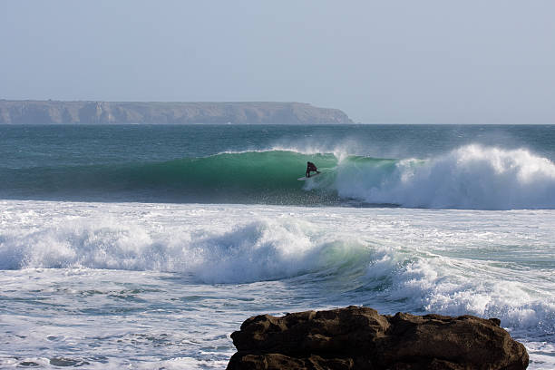 istock Surfer rides a wave at a reef in Porthleven 182403427