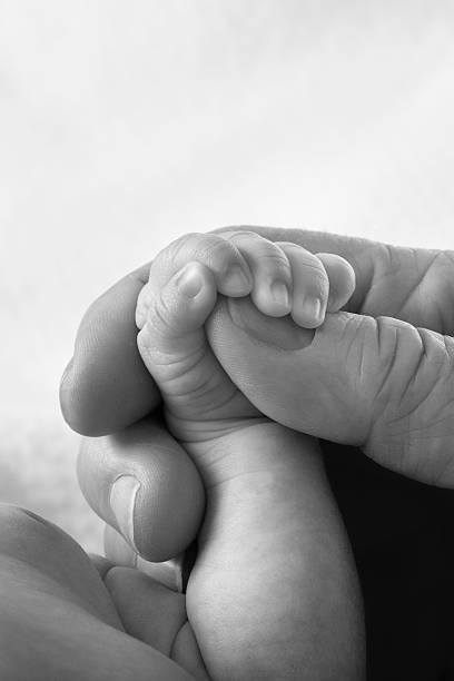 istock Newborn's Hand and Arm Being Lovingly Held by Adult 182403495