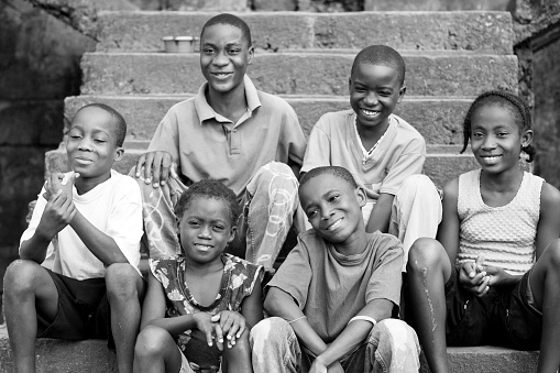 A group of African kids sitting on stairs.