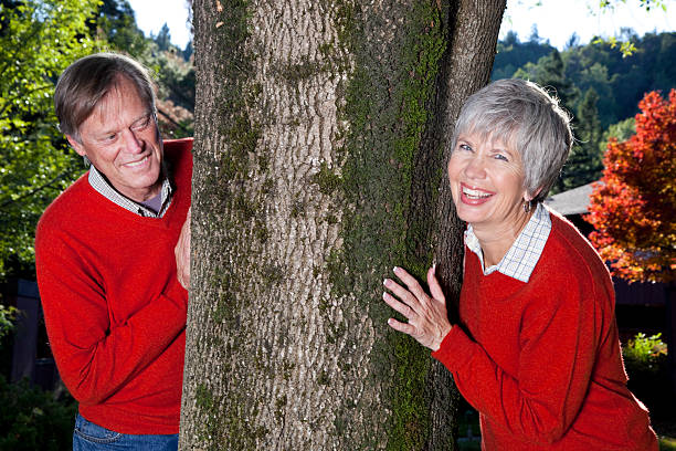 istock playful senior couple hugging a tree 182404076