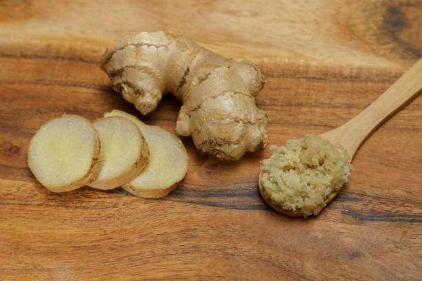 istock ground ginger in a wooden spoon with fresh ginger root 1824044603