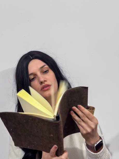 istock Young Caucasian female holding a book in her hands on a white background 1824046887