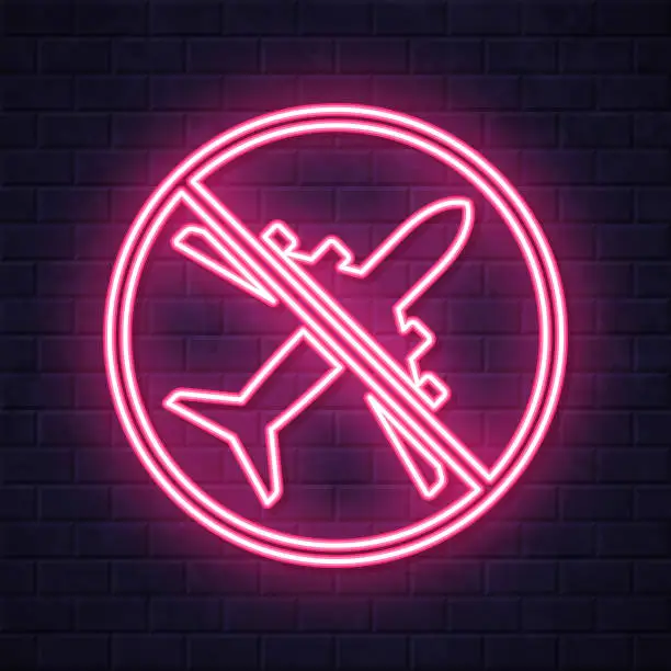 Vector illustration of Travel Ban. Glowing neon icon on brick wall background