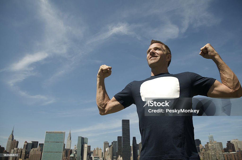 Guy en mensaje T Flexes músculos en Skyline - Foto de stock de Adulto libre de derechos