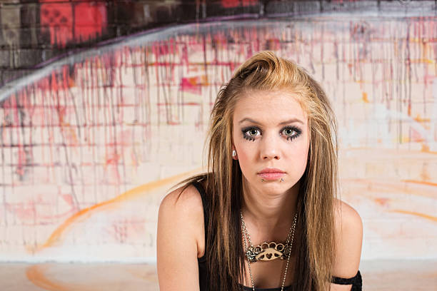 beautiful young blonde adult woman outdoors with brilliant graffiti background 