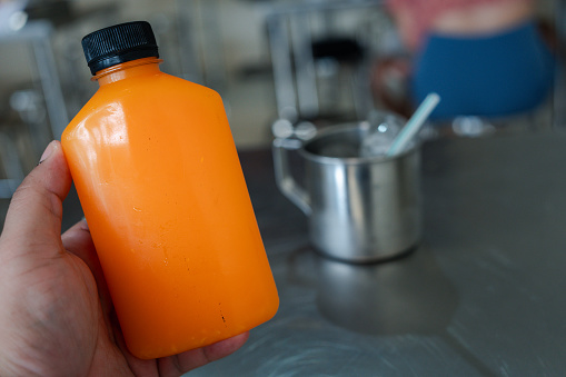 Male hand holding plastic bottles with orange juice. Orange juice for healthy day