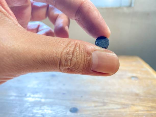 istock Activated charcoal pills on white background, top view. Potent sorbent 1824060226