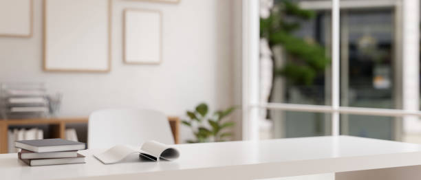 istock A study table or office desk with books and empty space on the white table in a modern white room. 1824066441