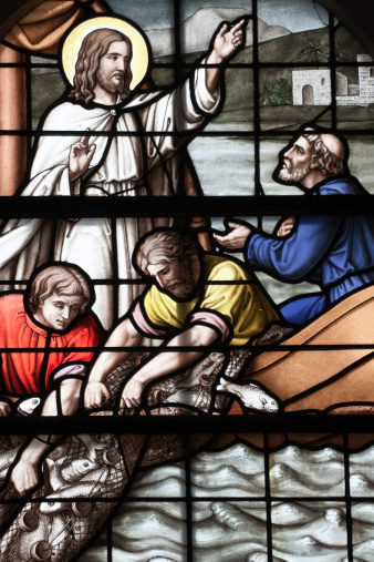 Stained glass window showing the miraculous catch of fish in the Sea of Galilee.