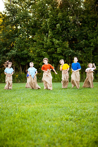 Happy Children Having a Fun Potato Sack Race Outside