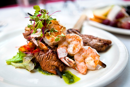 A elegantly presented plate of shrimp and beef skewers
