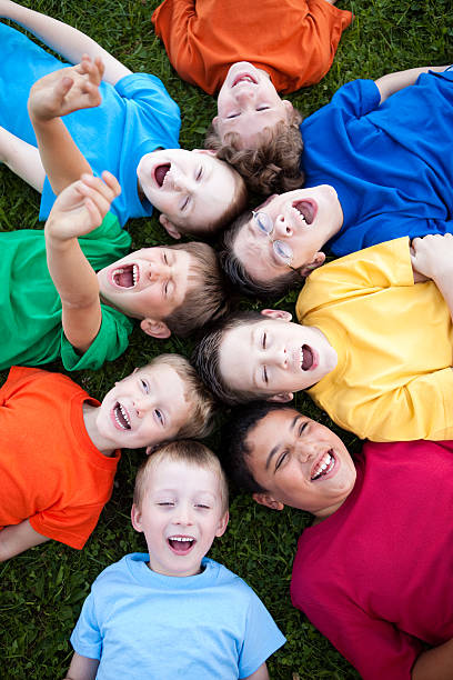 istock Happy Young Boys Yelling While Lying in a Circle Outside 182409214