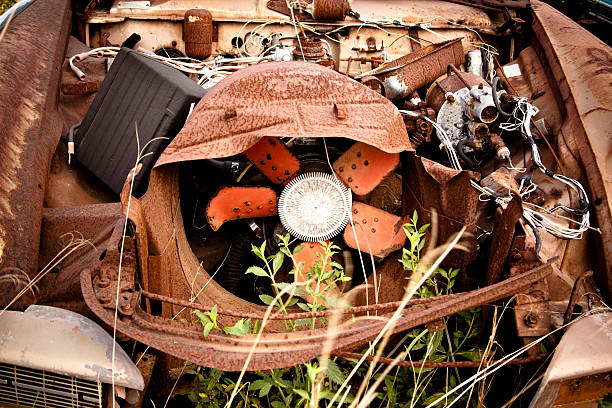 istock Wrecking Yard vehicle with weeds growing up through motor 182409256