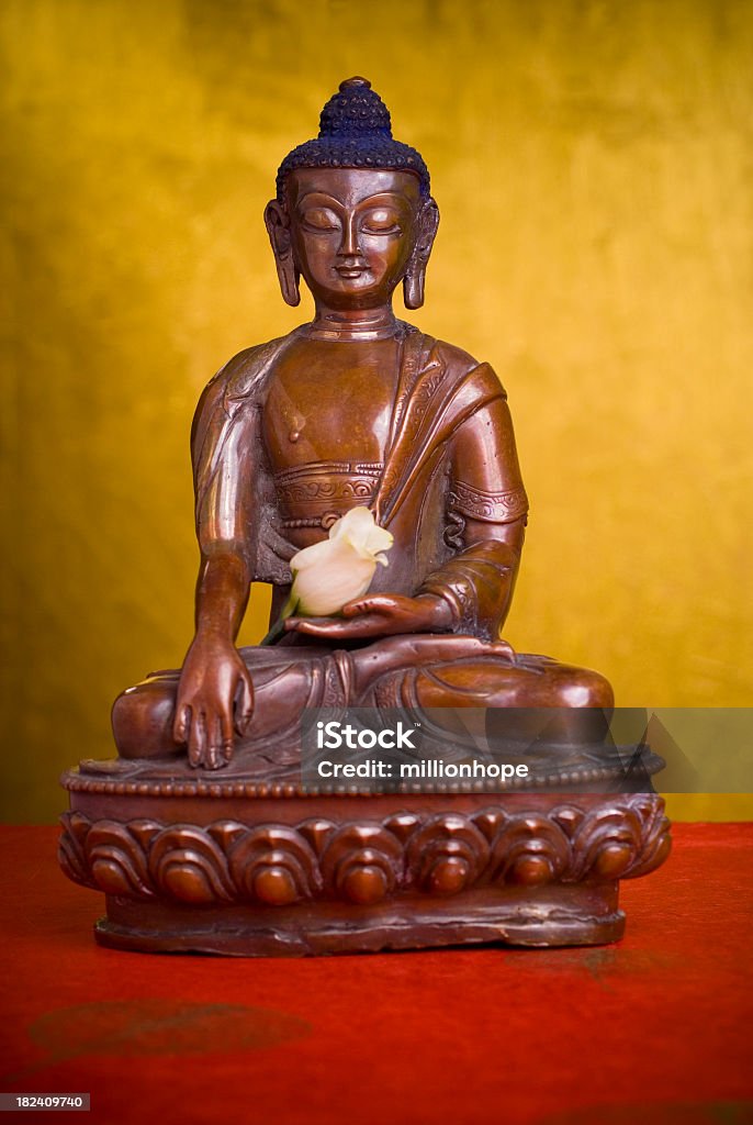 Buddha with flower Tibetan statue of the historic Buddha- Siddartha Gautama- or as often described as Buddha Shakyamuni Asia Stock Photo