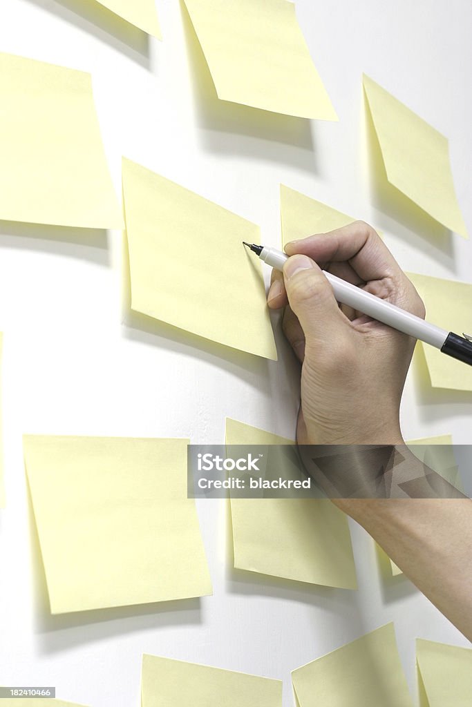 Writing Memo Writing on one of many sticky notes on white wall.Similar images - Adhesive Note Stock Photo