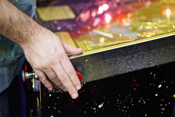 Playing Pinball Retro pinball game in an arcade. pinball machine stock pictures, royalty-free photos & images