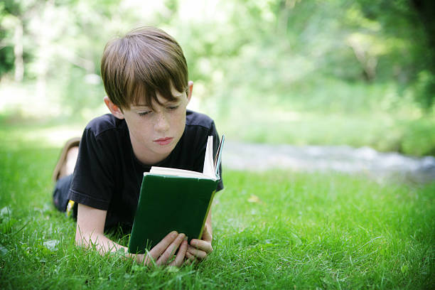 istock Happy Child Reading A Book Outside in Nature 182410767