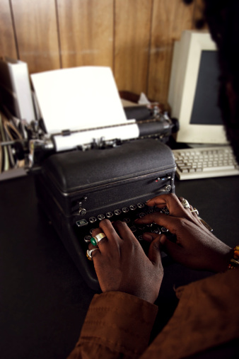 African American man using typewriter at desk.*Focus on hands