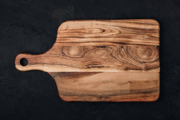 istock Wooden chopping board on dark stone background, top view 1824120452