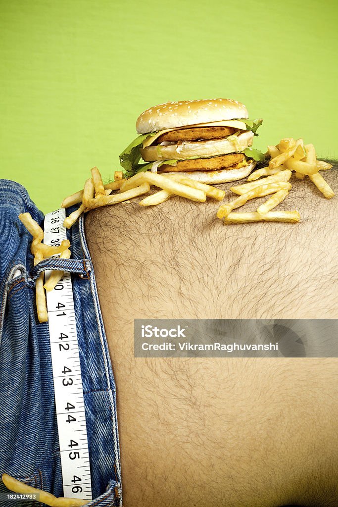 Hamburguesa y papas fritas coloca en el estómago - Foto de stock de Abdomen libre de derechos