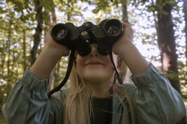 istock Cute little girl exploring nature looking through binoculars. Child playing outdoors. Kids travel, adventure and bird watching concept. 1824138896