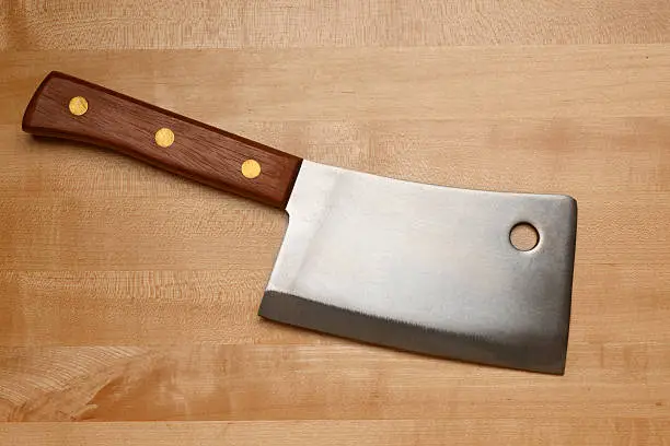 A meat cleaver on a cutting board.