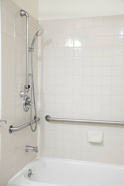 istock White Tile Bathroom Tub Shower with Grab Bars for Handicapped 182414212