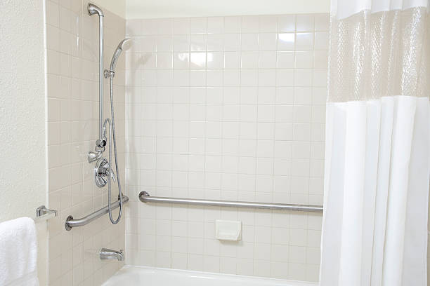 istock White Tiled Bathroom Tub Shower with Grab Bars for Handicapped 182414213