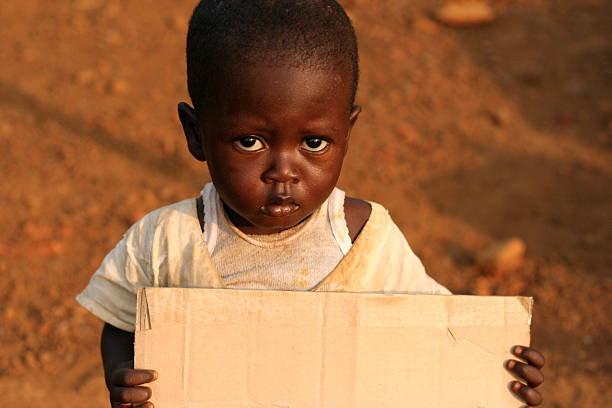 village hungry african boy eating some cheap biscuits, in the yard