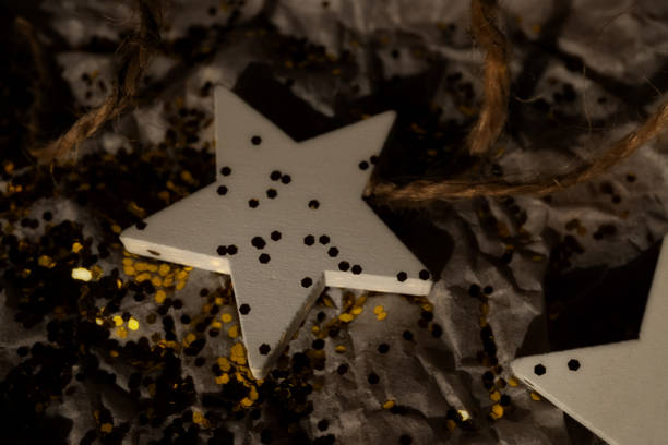 Festive still life showcasing a golden star ornament placed on glittering tinsel, surrounded by warm glowing lights and a dreamy blue bokeh background, creating a magical holiday ambiance. Native image size: 7952 x 5304.