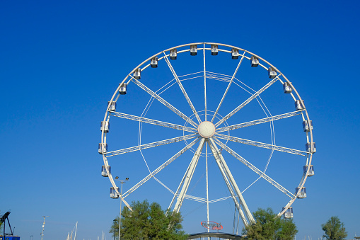 July 2023 Rimini, Italy: Ferris wheel across blue sky in the promenade of Rimini from beneath