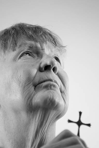istock Senior Woman Prays with Cross 182415913