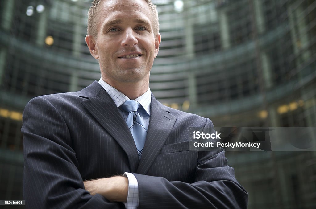 Biznesmen stoi przed zakrzywioną Office Tower - Zbiór zdjęć royalty-free (30-39 lat)