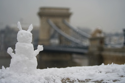 Budapest, Hungary - November 30, 2023: Snowman with the Chain bridge on the background.