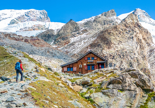 Scenic winter landscape on the top of the mountain, white snow, a rooftop of wooden hut, alps