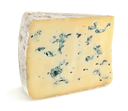 Blue cheese with walnuts and fresh greens on a black background.