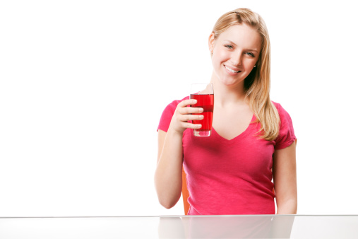 Subject: A healthy young woman with a glass of cranberry juice.