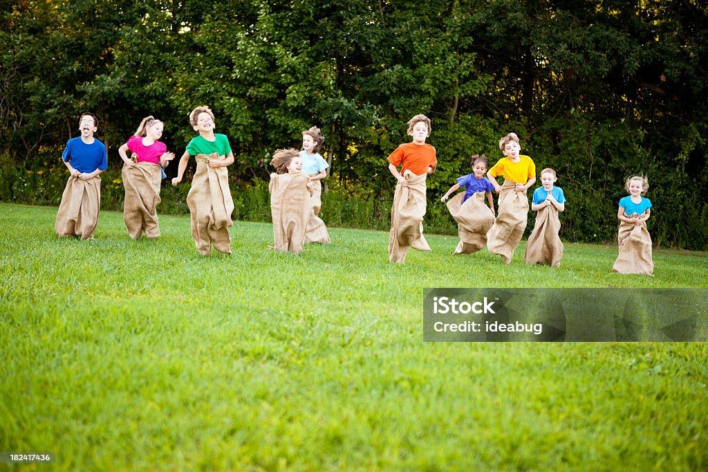 Glückliche Kinder haben Spaß-Kartoffel-Sack Race außerhalb - Lizenzfrei Sackhüpfen Stock-Foto