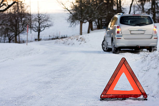 istock SUV stuck on a snowy road, protected by a hazard sign 182417535